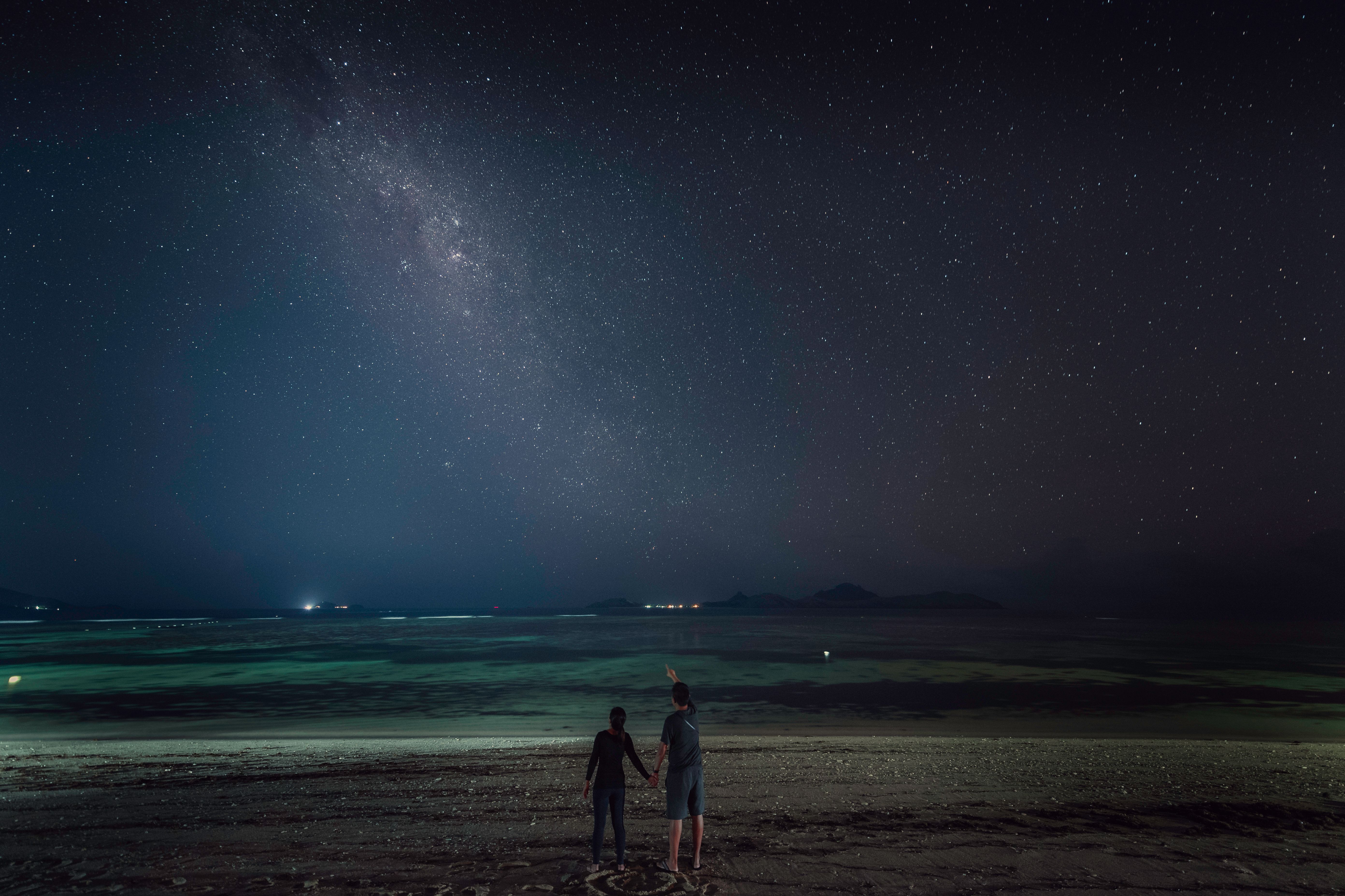 The Zodiac Signs Most Likely to Crave an Authentic ‘Girlfriend Energy’ Connection Romantic couple holding hands while stargazing beneath the night sky, blending astrology and intimacy.